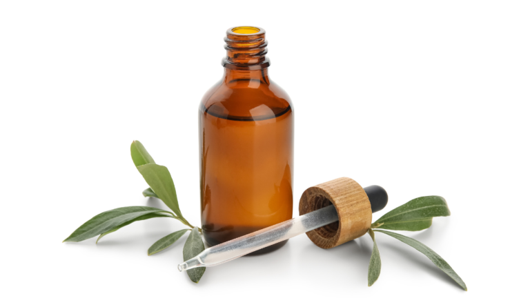 Tea tree oil bottle with fresh tea tree leaves for Demodex-prone skin, scalp, and eyelid care